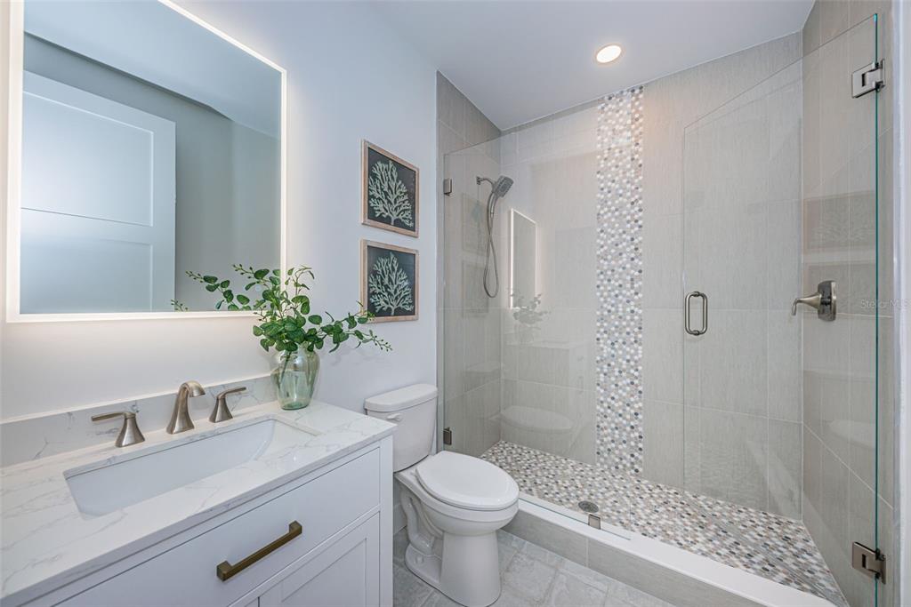 12305 3rd Street East, Unit 2 Treasure Island, FL 33706 - Photo 50 of 69 a bathroom with a sink toilet and shower