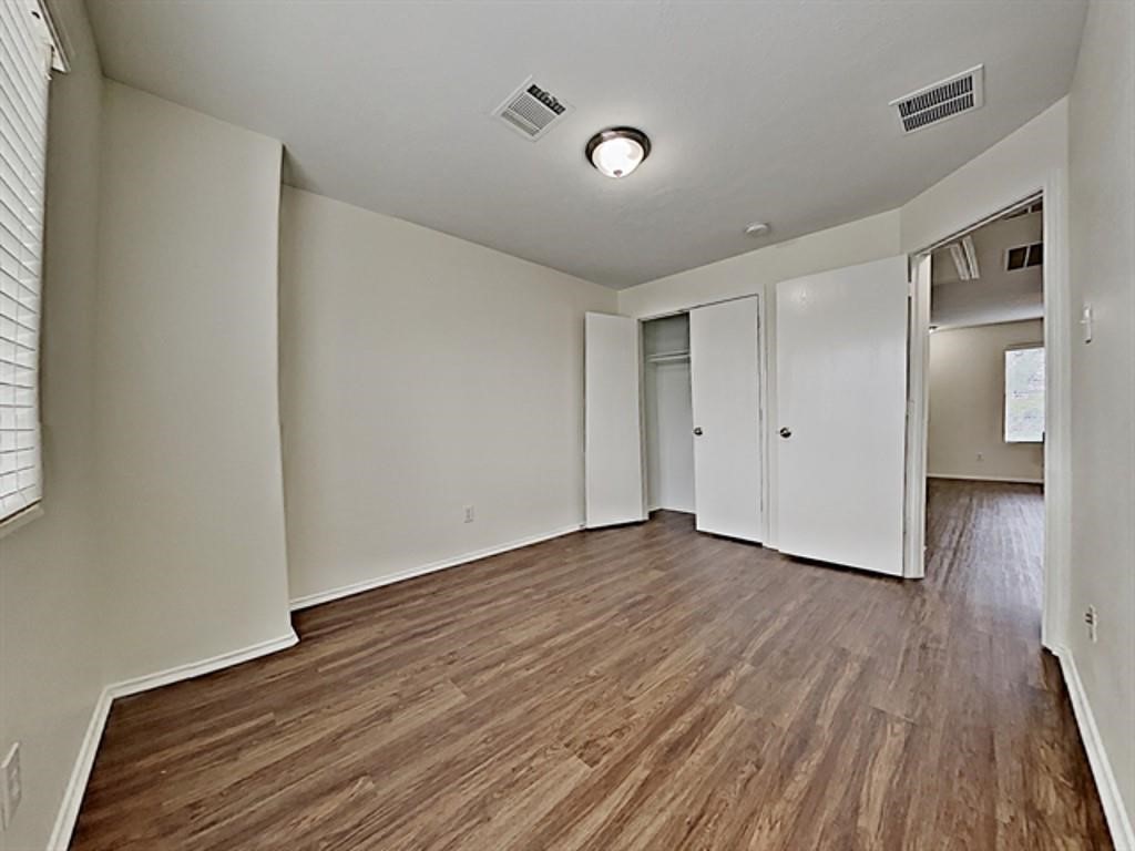 6830 Shallow River Court Spring, TX 77379 - Photo 16 of 17 a view of an empty room with wooden floor and a window