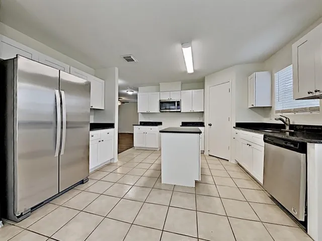 a kitchen with stainless steel appliances a refrigerator sink and cabinets
