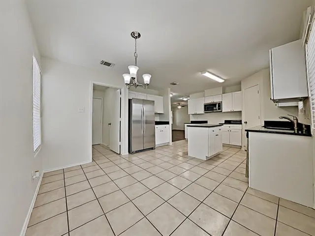 a large white kitchen with cabinets