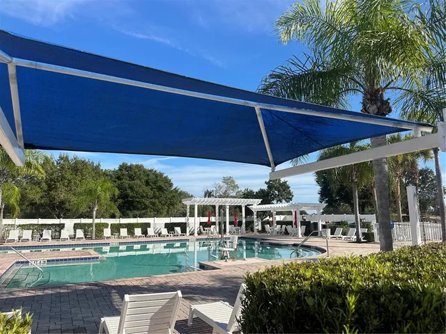 a view of a patio with lawn chairs under an umbrella
