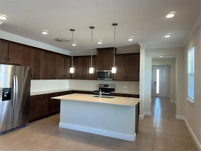 a kitchen with kitchen island a sink stainless steel appliances and cabinets