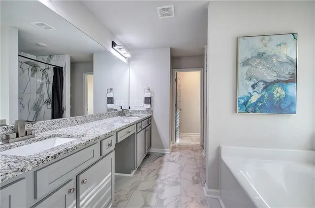 a white bath tub sitting in a bathroom next to a window
