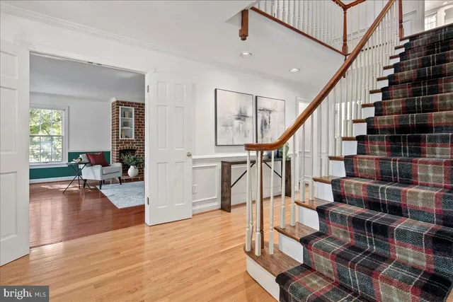 a view of a kitchen with stainless steel appliances wooden floor and living room