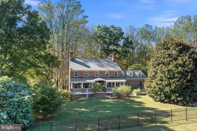 a view of a house with a yard deck and a large tree