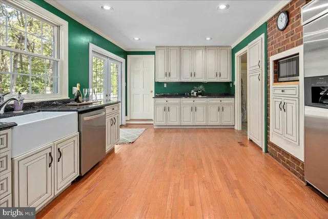 a kitchen with a sink a window cabinets and a wooden floor