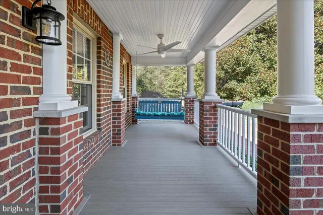 a view of an entryway with wooden floor leading to a furnished livingroom and windows