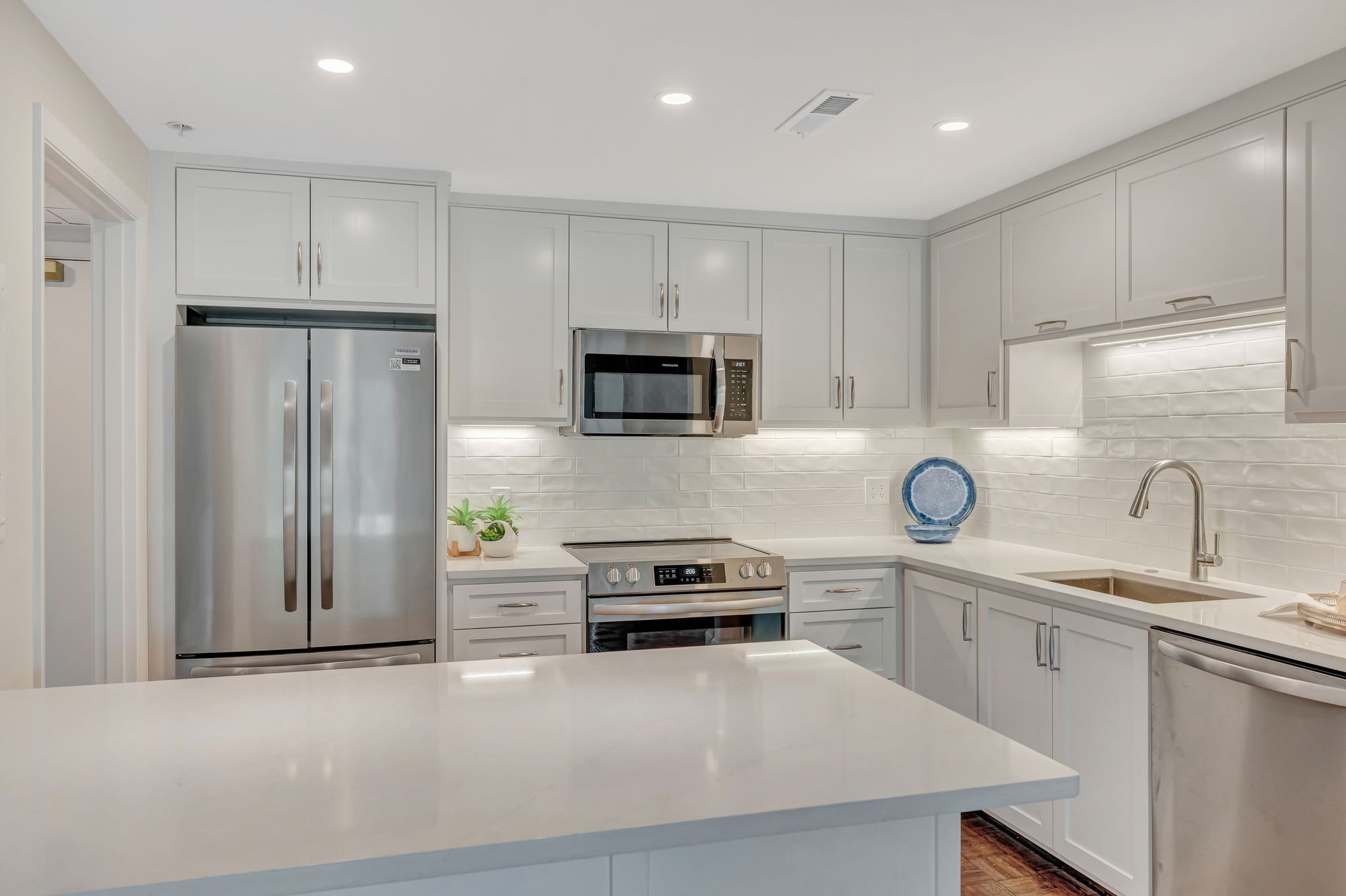 a kitchen with granite countertop a refrigerator stove and sink