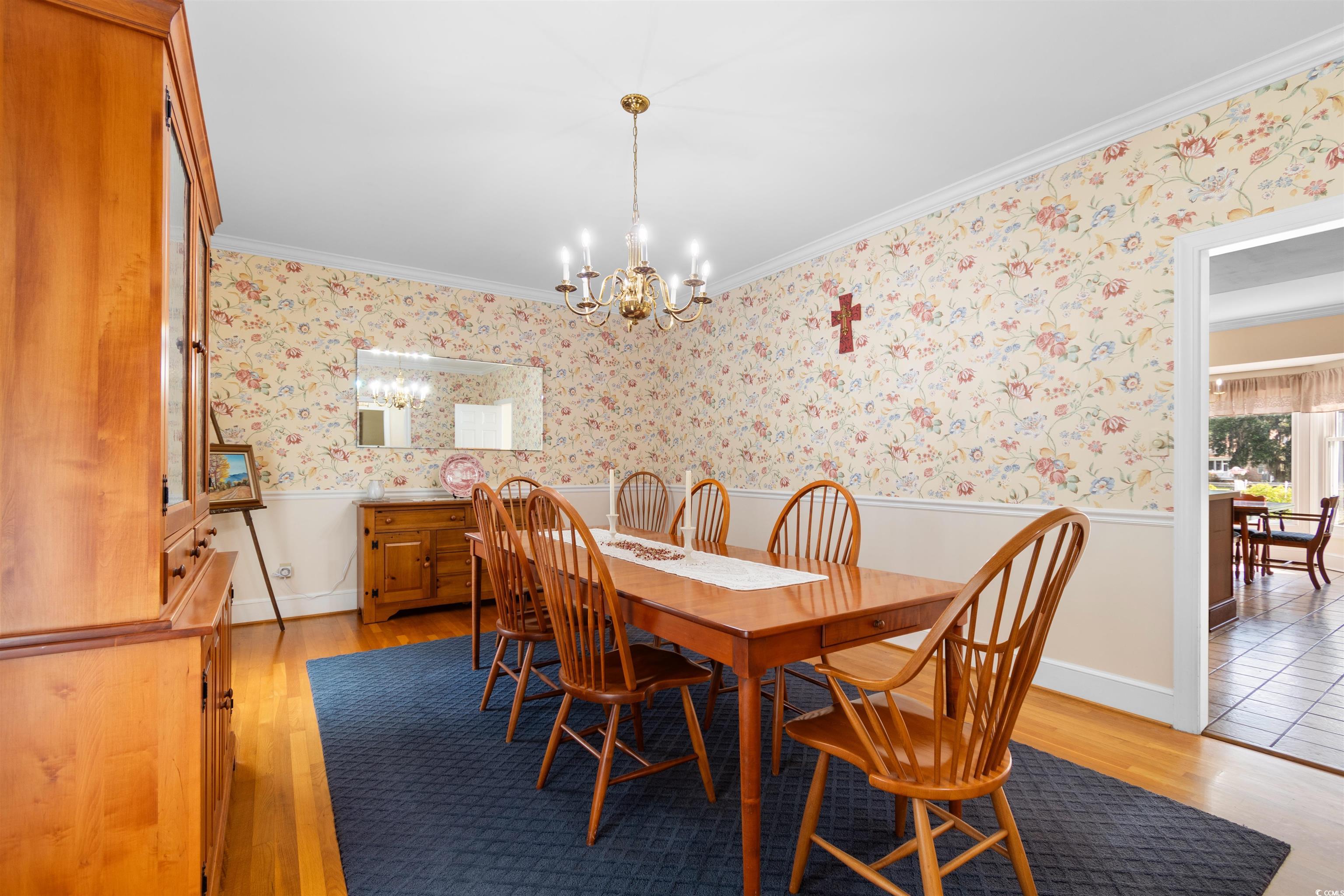 14 Live Oak Lane Georgetown, SC 29440 - Photo 16 of 40 Dining room with a wainscoted wall, crown molding, original hardwood flooring, a chandelier, and wallpapered walls