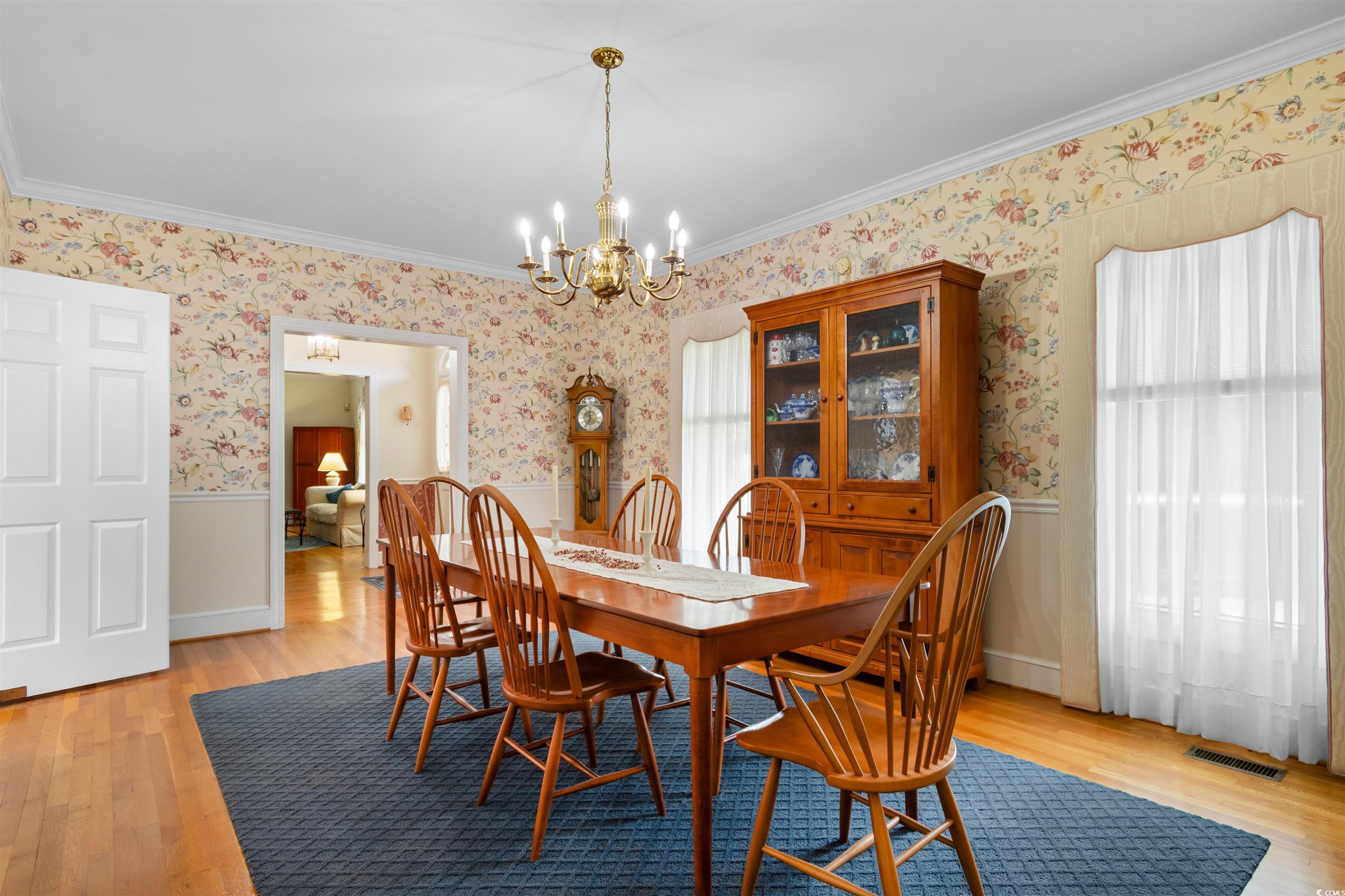 14 Live Oak Lane Georgetown, SC 29440 - Photo 17 of 40 Dining space featuring original hardwood floors, ornamental molding, a chandelier, wallpapered walls, and wainscoting