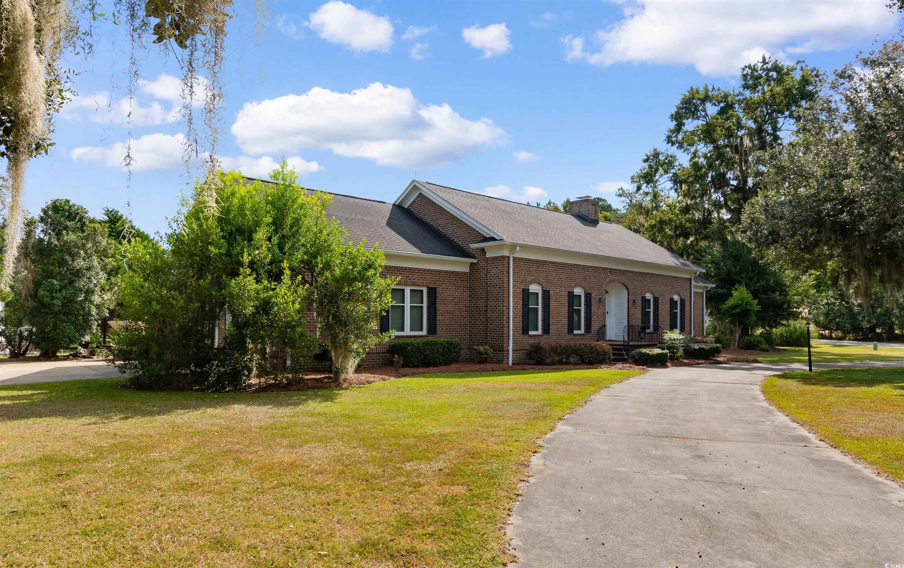 14 Live Oak Lane Georgetown, SC 29440 - Photo 2 of 40 View of front facade with a front lawn, brick siding, driveway, and a chimney