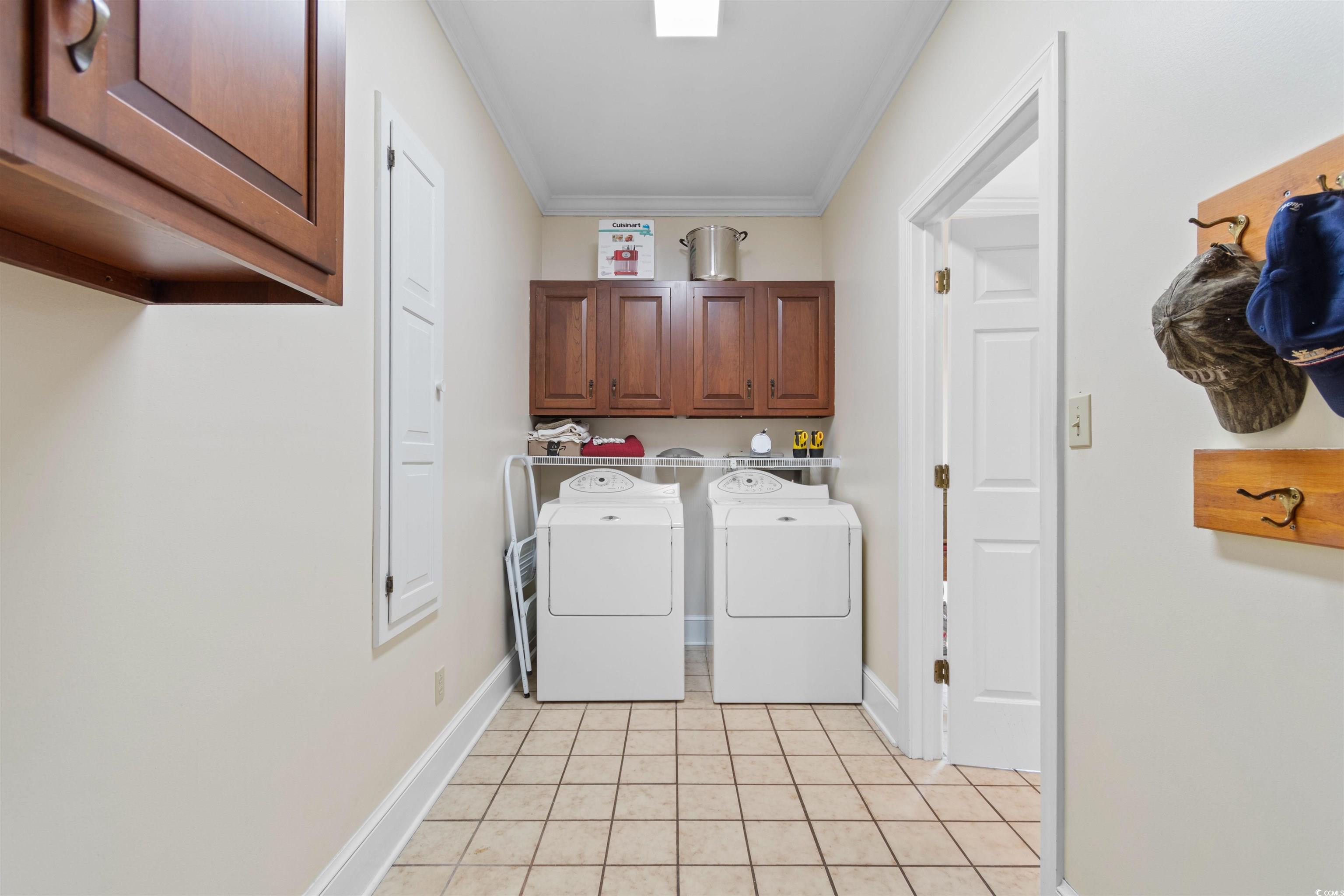 14 Live Oak Lane Georgetown, SC 29440 - Photo 28 of 40 Washroom with cabinet space, light tile patterned floors, crown molding, and washer and clothes dryer