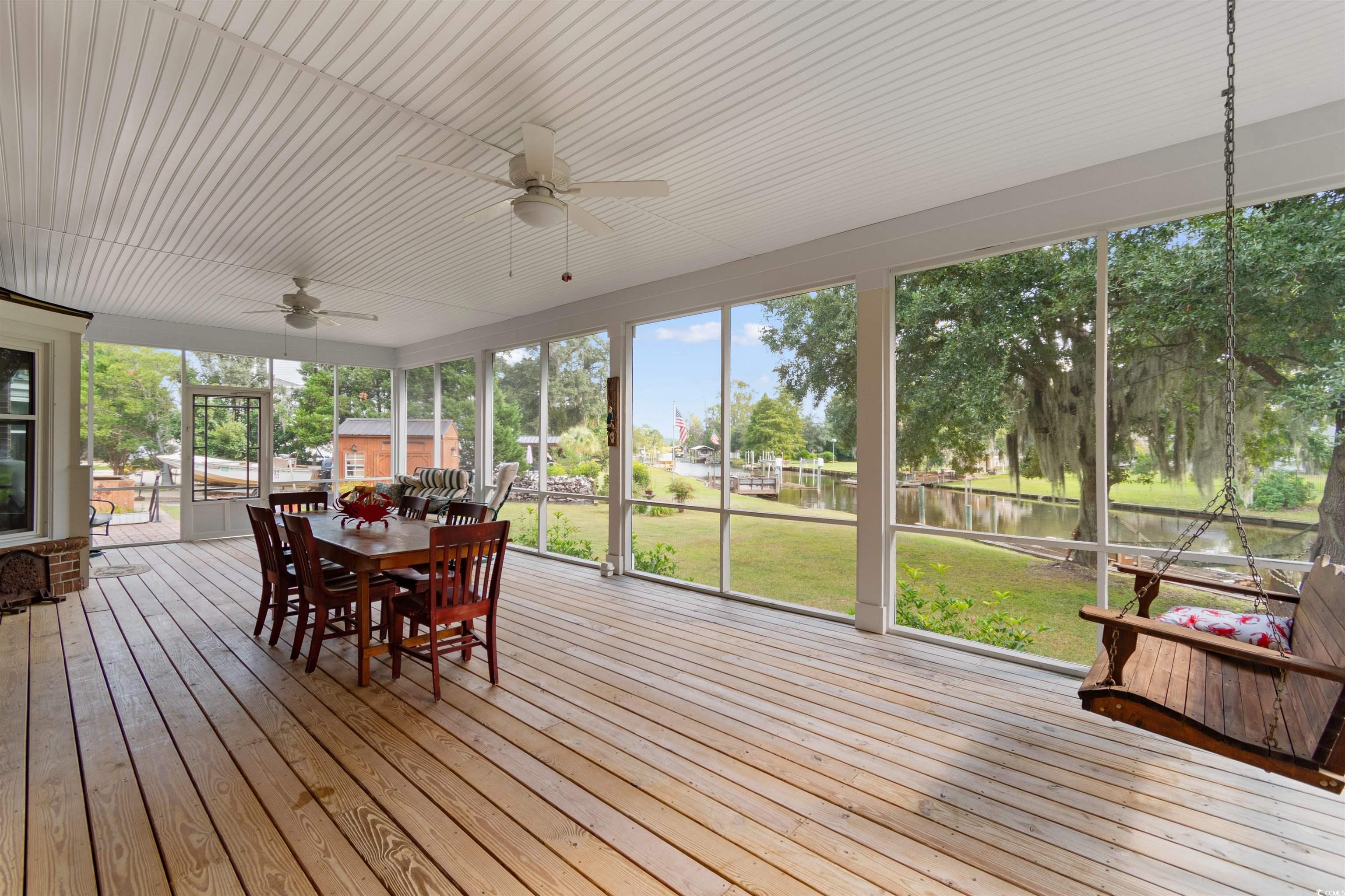 14 Live Oak Lane Georgetown, SC 29440 - Photo 29 of 40 Screened porch featuring a ceiling fan, outdoor dining area, and a deck with water view