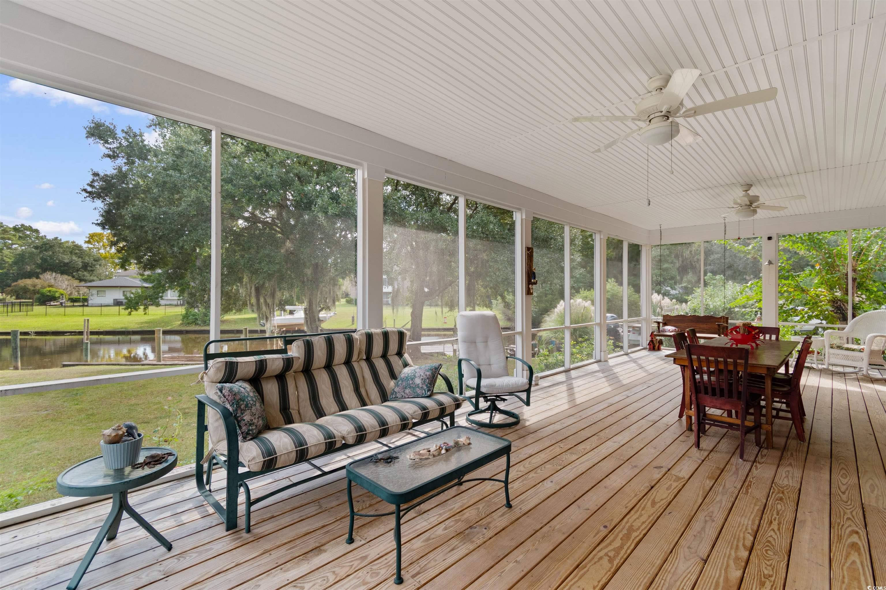 14 Live Oak Lane Georgetown, SC 29440 - Photo 30 of 40 Screened porch with an outdoor hangout area, a ceiling fan, outdoor dining space, and a deck with water view