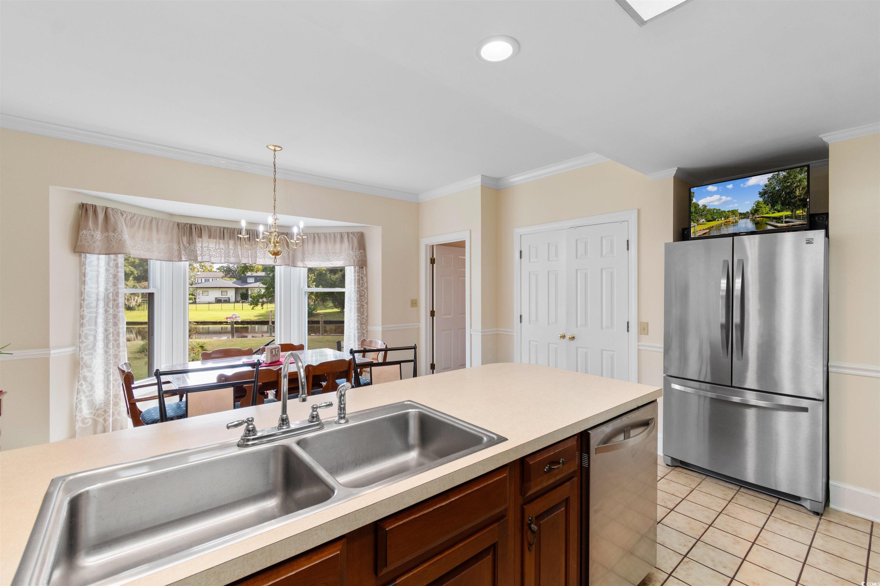 14 Live Oak Lane Georgetown, SC 29440 - Photo 8 of 40 Kitchen with stainless steel appliances, healthy amount of natural light, ornamental molding, light countertops, and a chandelier