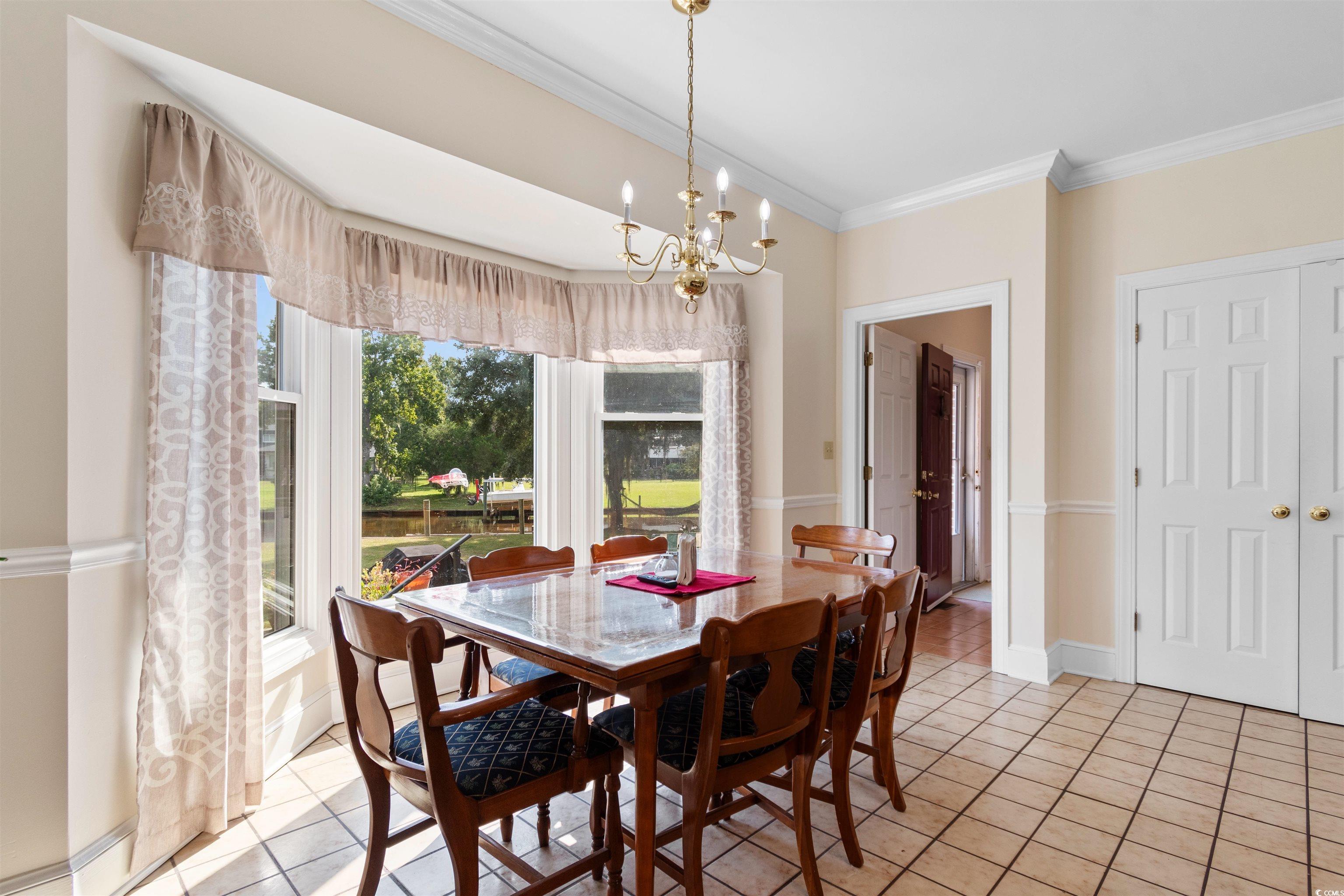 14 Live Oak Lane Georgetown, SC 29440 - Photo 9 of 40 Dining room featuring crown molding, a chandelier, and light tile patterned floors