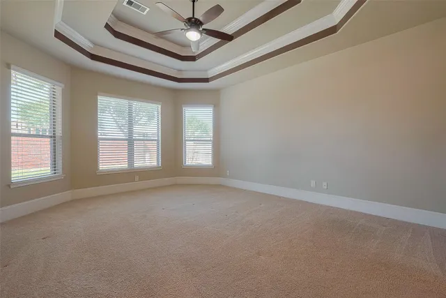 an empty room with windows and fan