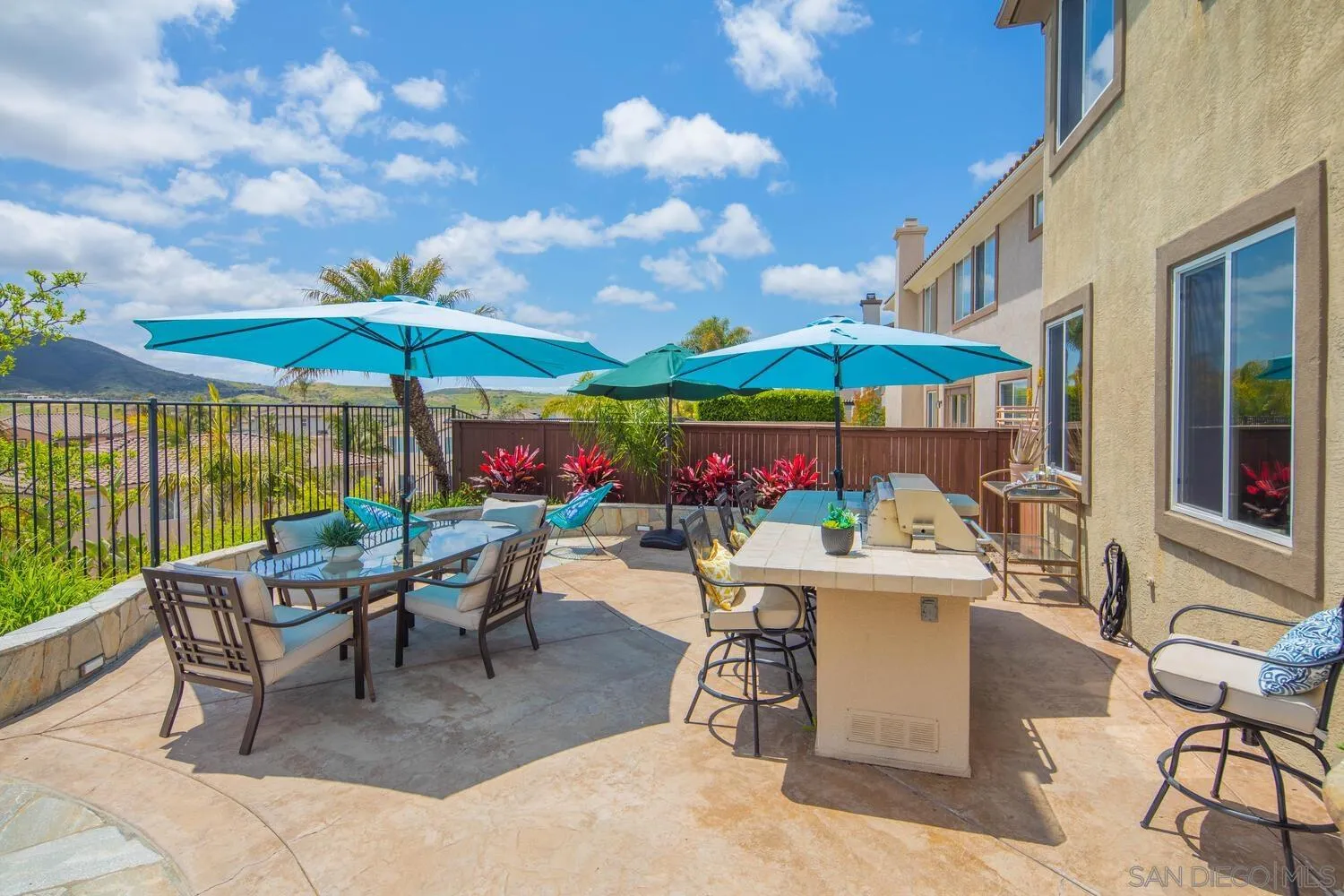 16327 Pinto Ridge Drive 4S Ranch, CA 92127 - Photo 58 of 74 a view of a patio with chairs and table under an umbrella with a barbeque