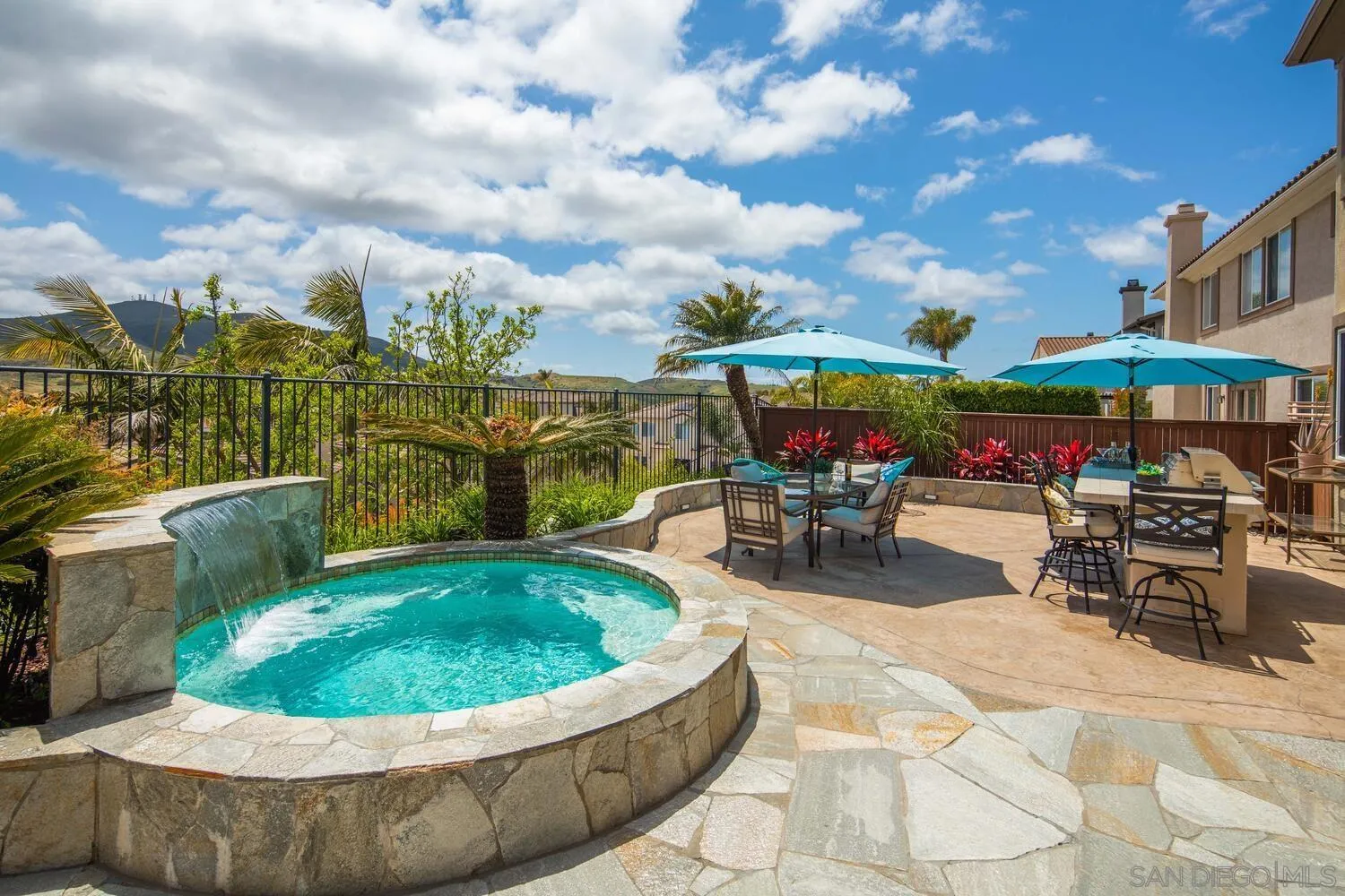 16327 Pinto Ridge Drive 4S Ranch, CA 92127 - Photo 61 of 74 a view of a patio with dining table and chairs under an umbrella