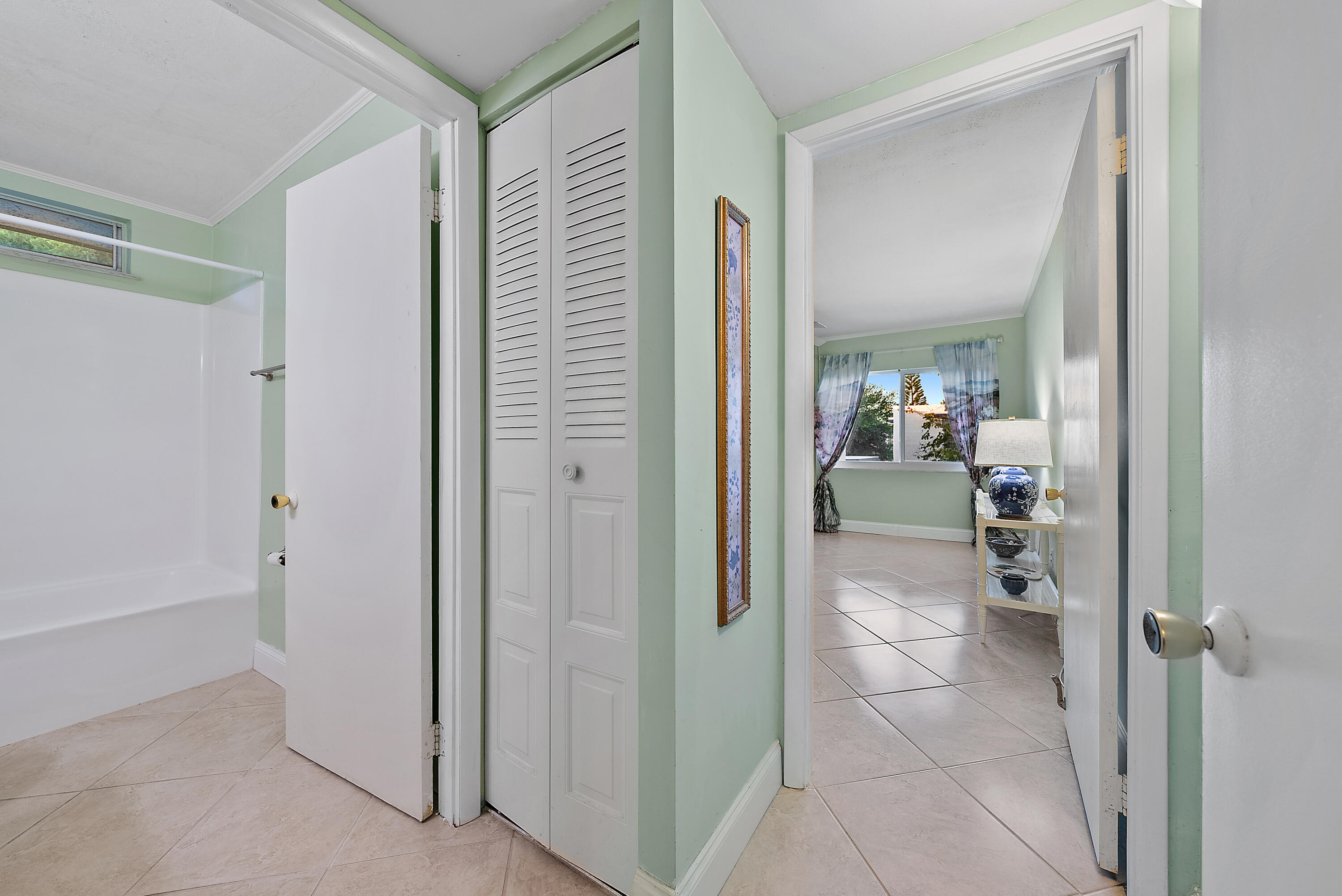 1561 Northeast 12th Terrace, Unit C14 Jensen Beach, FL 34957 - Photo 16 of 27 a bathroom with a glass door shower a mirror and a sink