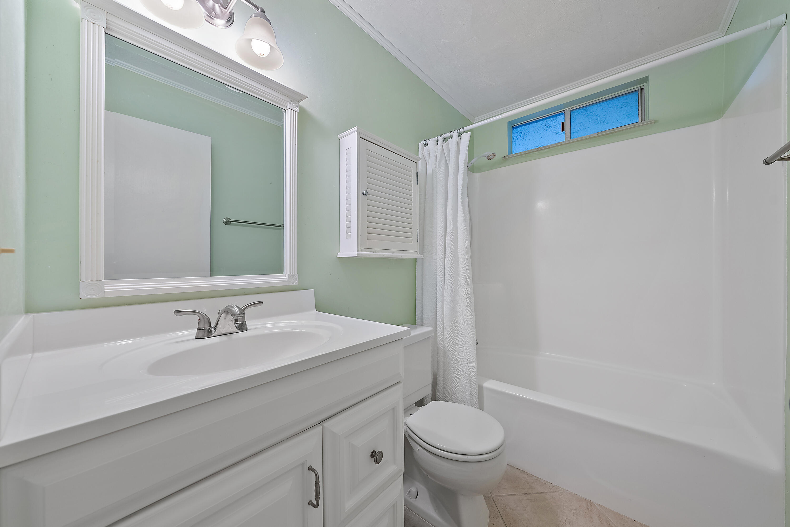1561 Northeast 12th Terrace, Unit C14 Jensen Beach, FL 34957 - Photo 18 of 27 a bathroom with a sink a toilet and shower
