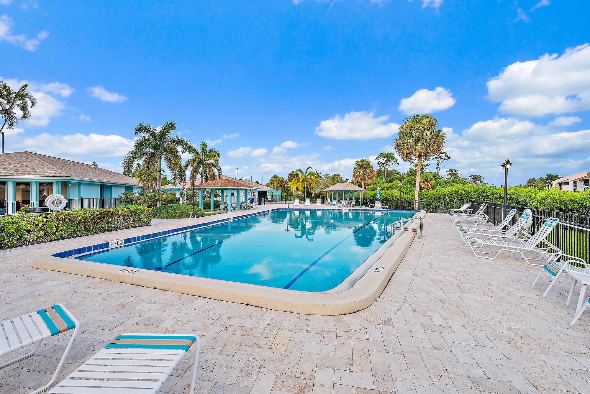 1561 Northeast 12th Terrace, Unit C14 Jensen Beach, FL 34957 - Photo 22 of 27 a view of a swimming pool with a lounge chairs