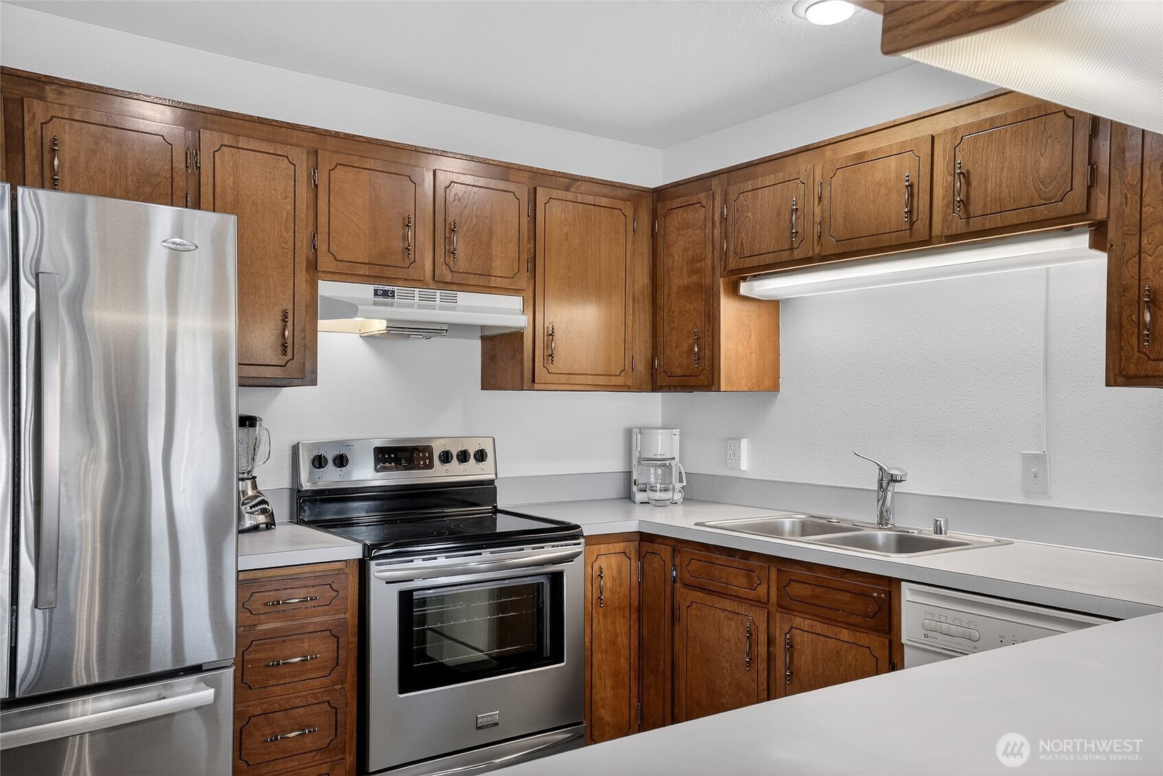 2001 Skyline Way, Unit 103 Anacortes, WA 98221 - Photo 15 of 39 a kitchen with stainless steel appliances a stove a sink and a refrigerator with wooden cabinets