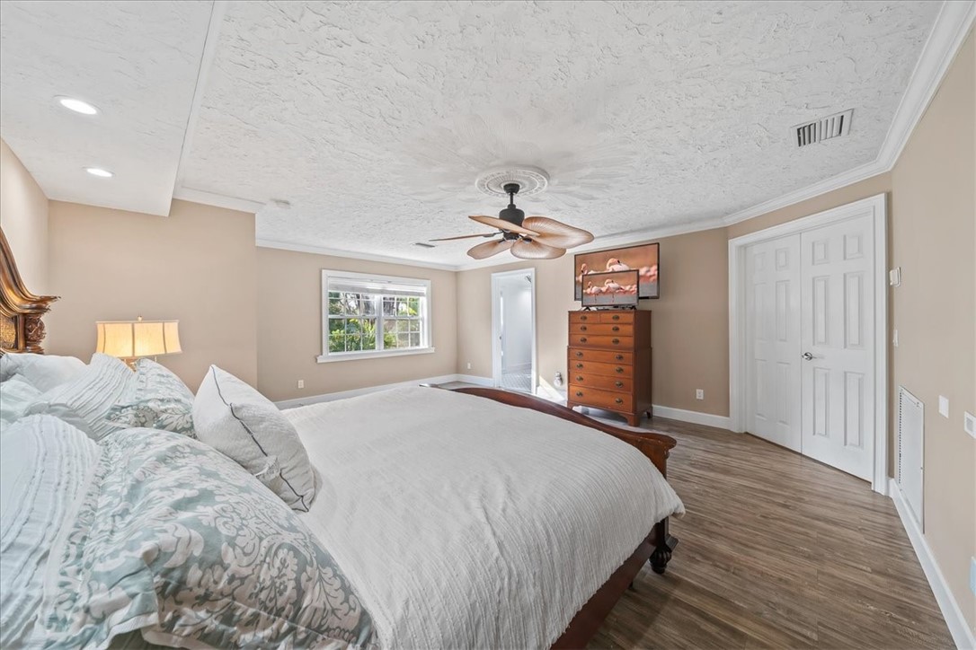 9670 Mockingbird Lane Sebastian, FL 32976 - Photo 14 of 36 a spacious bedroom with a large bed chandelier and a window