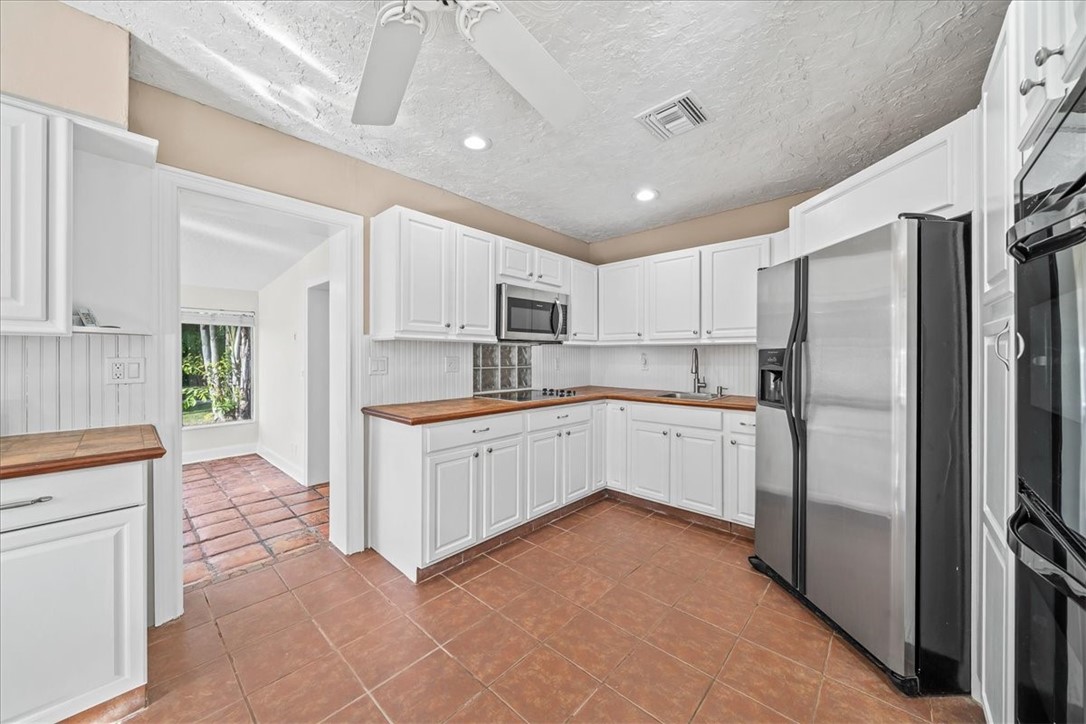 9670 Mockingbird Lane Sebastian, FL 32976 - Photo 7 of 36 a large kitchen with cabinets and stainless steel appliances