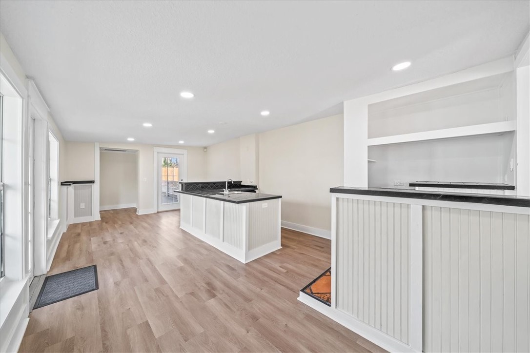 9670 Mockingbird Lane Sebastian, FL 32976 - Photo 10 of 36 a large white kitchen with kitchen island a sink wooden floor and a refrigerator