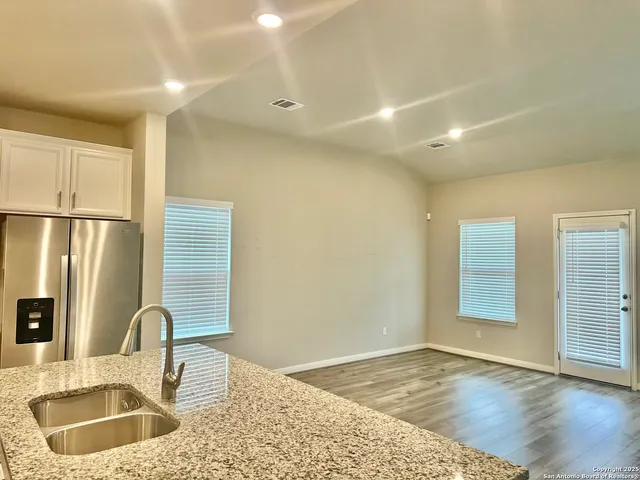 a kitchen with stainless steel appliances granite countertop a sink a stove and refrigerator