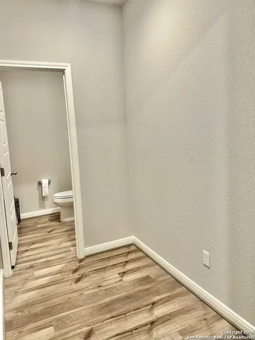 a view of a room with wooden floor and white walls