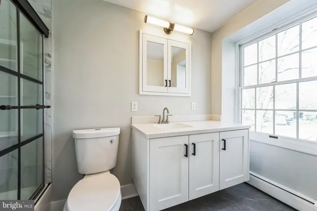 a bathroom with a toilet sink and mirror