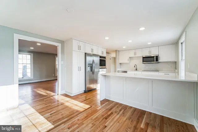 a view of kitchen with wooden floor and electronic appliances