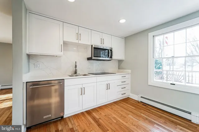 a kitchen with granite countertop white cabinets and stainless steel appliances