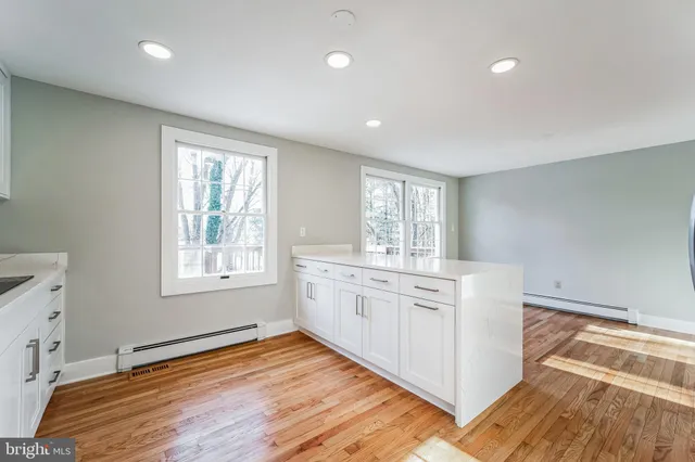 a view of a kitchen counter space with wooden floor and staircase