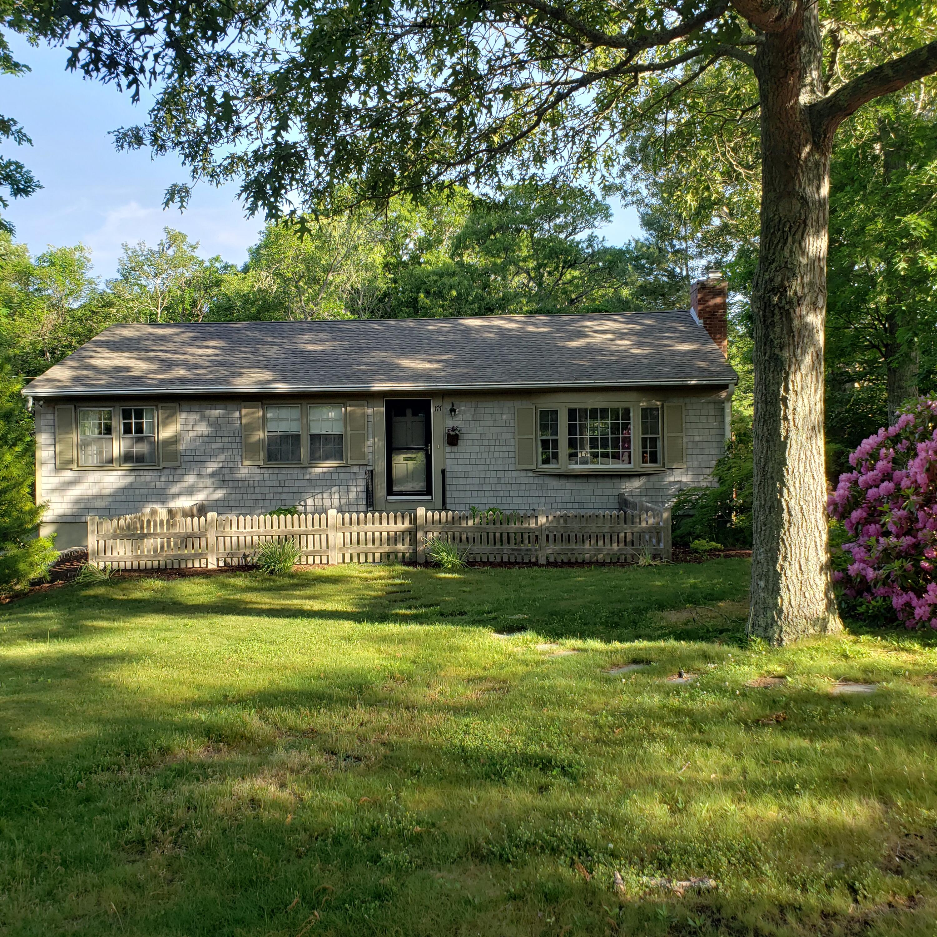 a front view of house with yard and trees