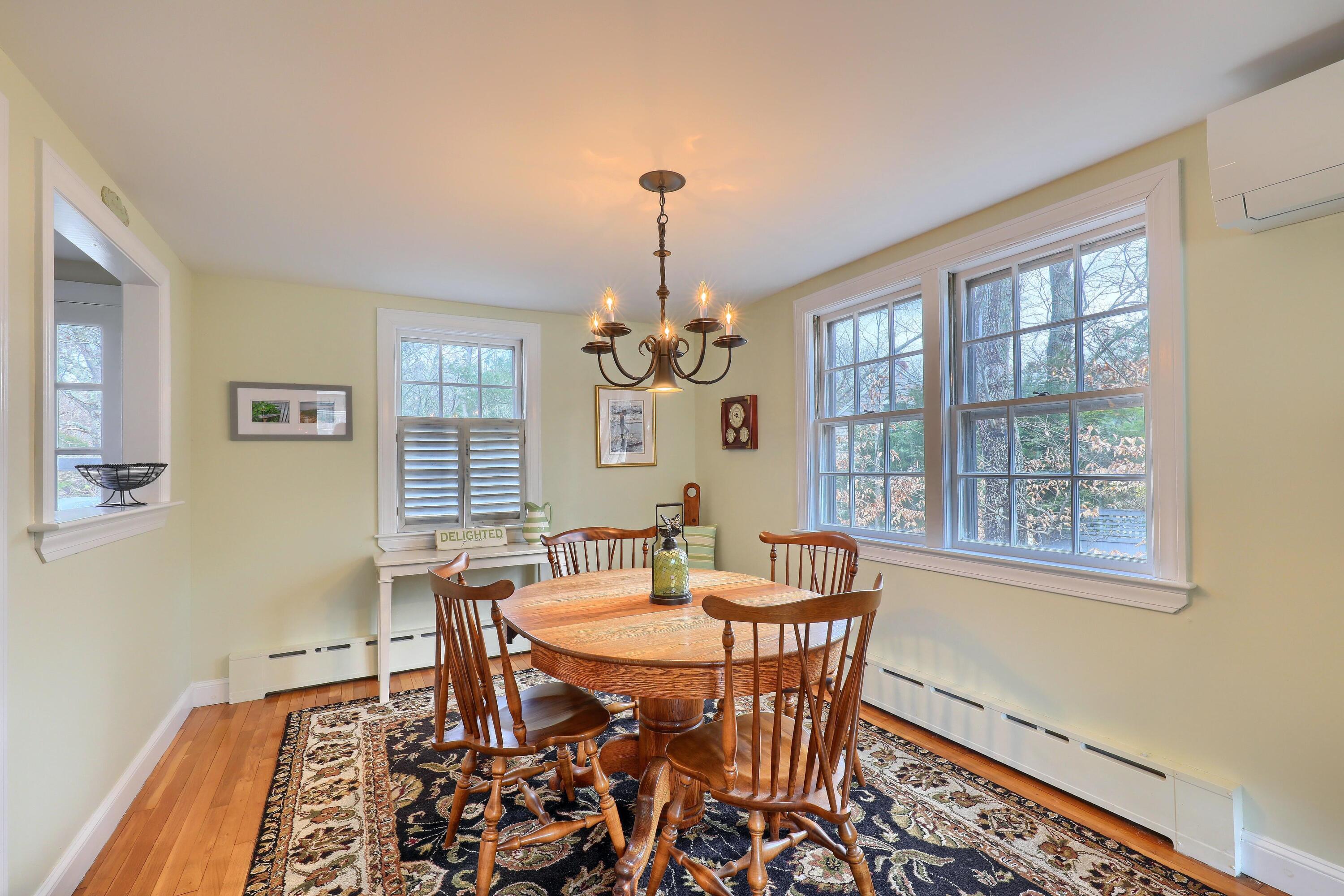 177 Old Stage Road Centerville, MA 02632 - Photo 9 of 29 a dining room with furniture a chandelier and wooden floor