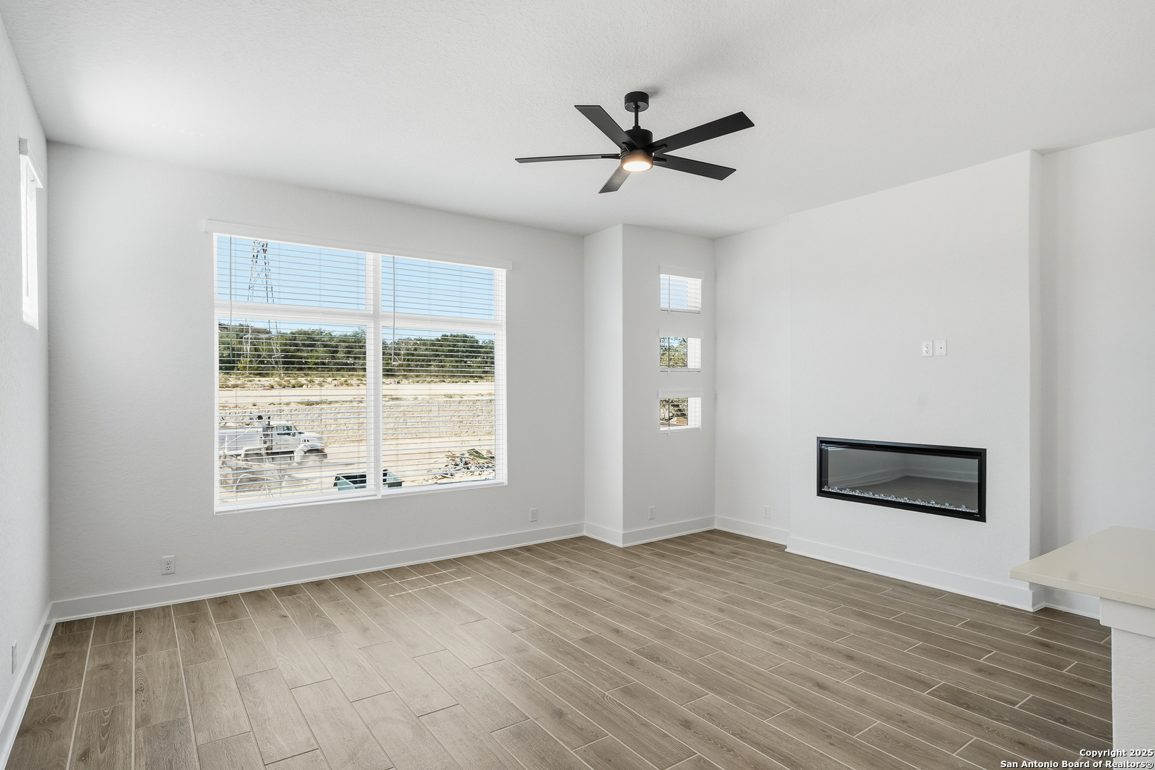 20675 Huebner Road, Unit 526 San Antonio, TX 78258 - Photo 7 of 45 a view of an empty room with a window and wooden floor