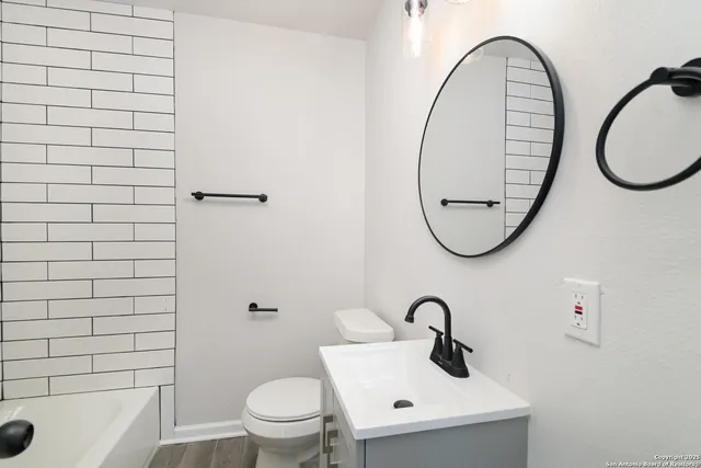 a bathroom with a sink a mirror a toilet and a shower