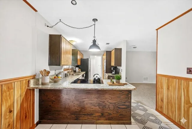 a kitchen with stainless steel appliances granite countertop a sink and a refrigerator