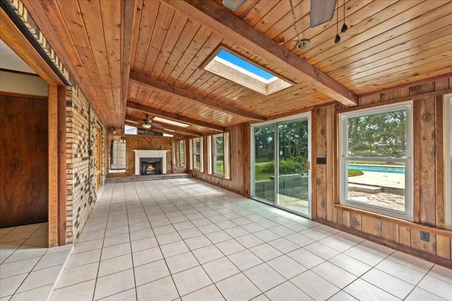 a living room with furniture a large window and gym equipment