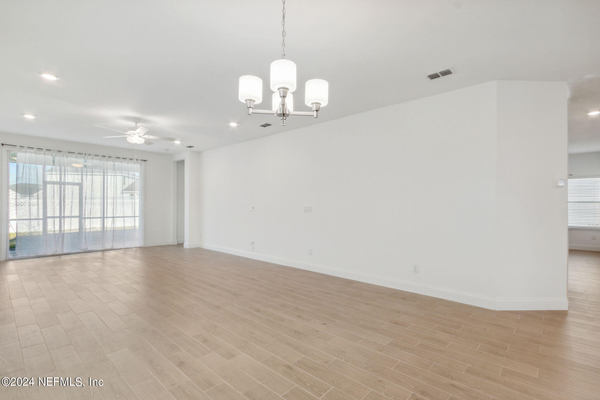 125 Varner Way St. Augustine, FL 32092 - Photo 18 of 87 a view of an empty room with wooden floor and windows