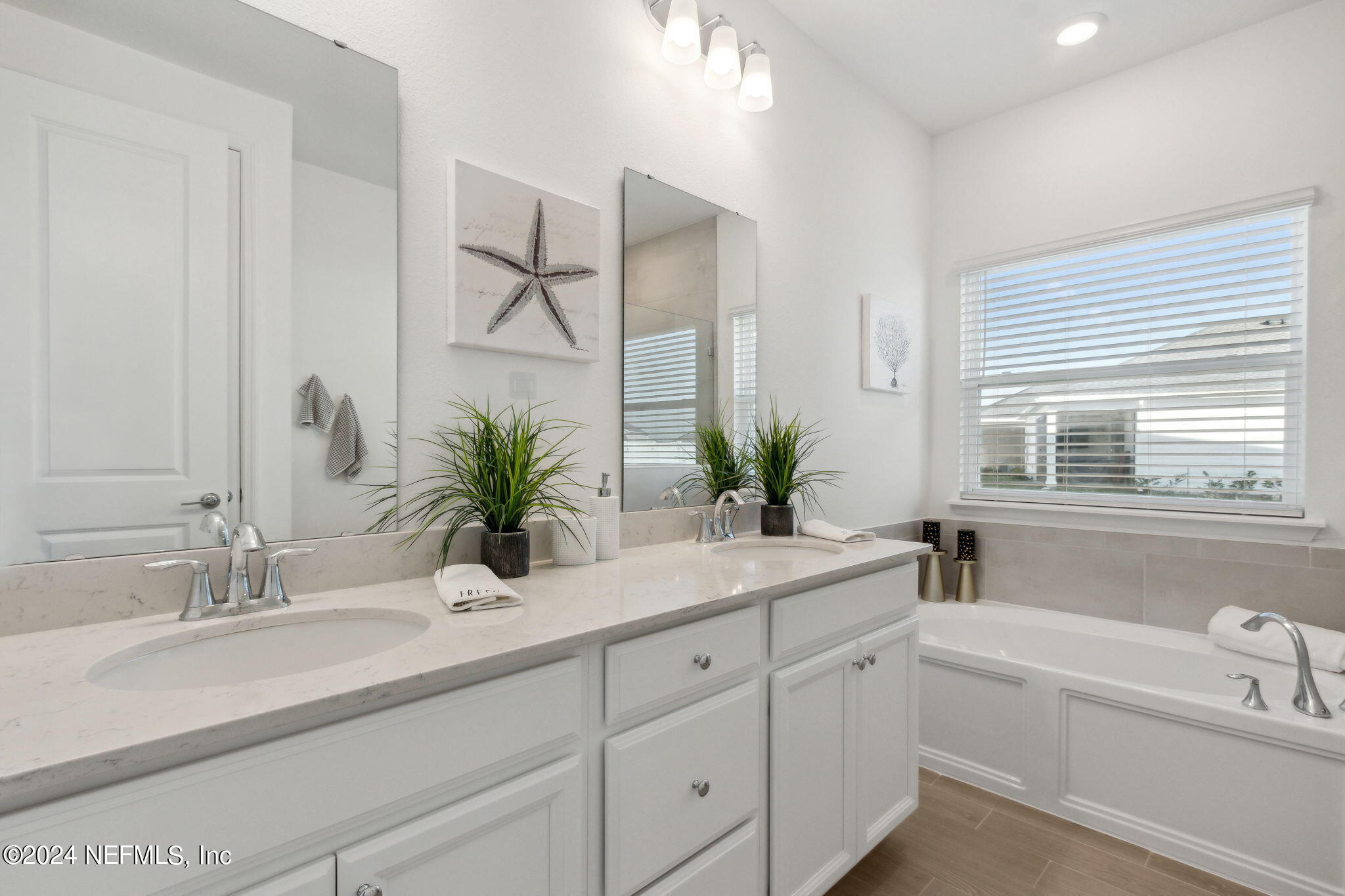 125 Varner Way St. Augustine, FL 32092 - Photo 29 of 87 a bathroom with a tub a sink a large mirror and vanity