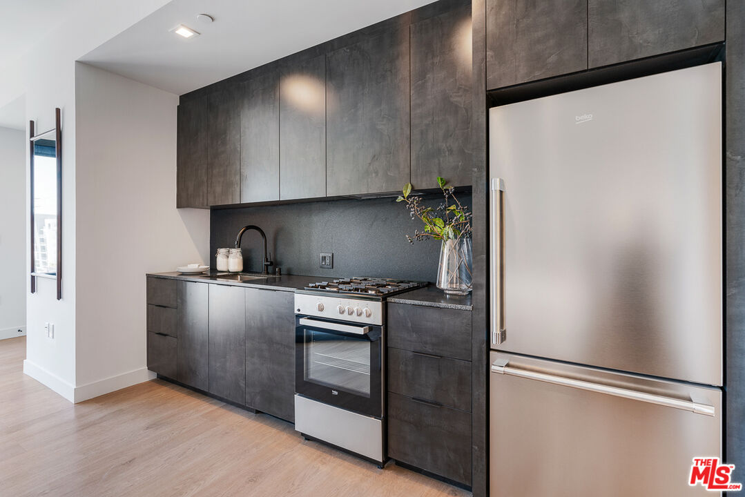 10700 Tabor Street, Unit PH5 Los Angeles, CA 90034 - Photo 4 of 26 a kitchen with metallic refrigerator and a stove