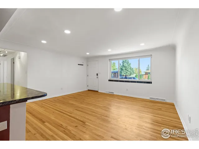 a view of empty room with wooden floor
