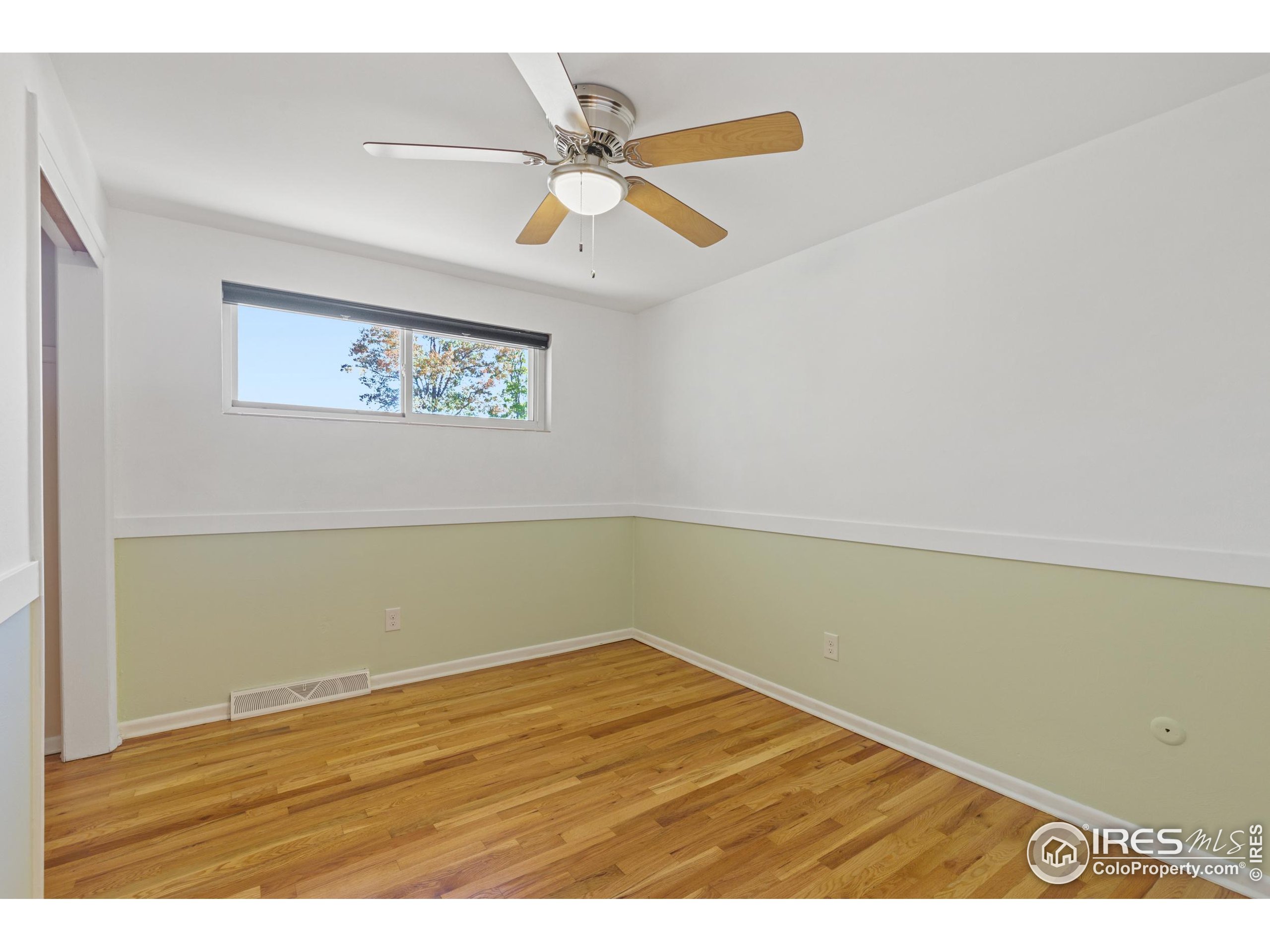 725 South 45th Street Boulder, CO 80305 - Photo 21 of 44 an empty room with wooden floor and fan