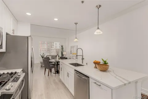 a kitchen with stainless steel appliances granite countertop a sink a stove and a refrigerator