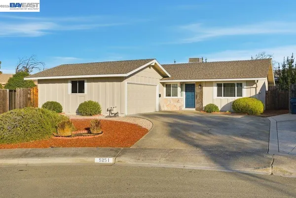 a front view of house with yard and trees around
