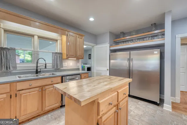 a kitchen with kitchen island a counter top space cabinets stainless steel appliances and a counter space